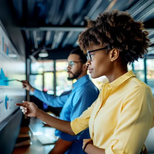 Two individuals analyzing a chart