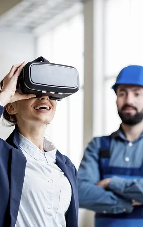 A woman wearing VR glasses while a man watches