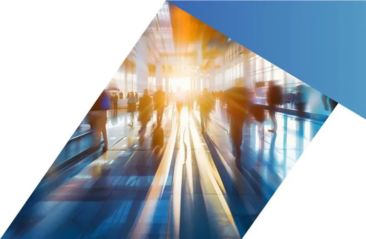 People walking through a sunlit airport terminal