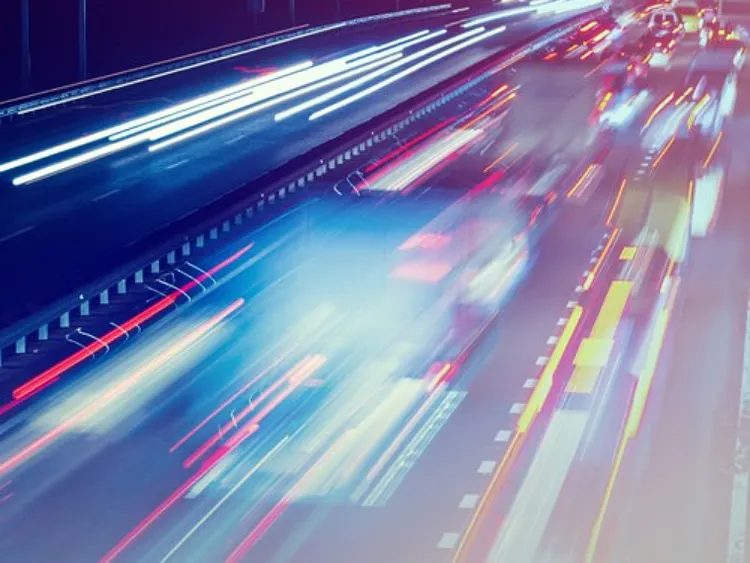 A night highway blazes with vibrant light trails, capturing the swift momentum of technological advancement.