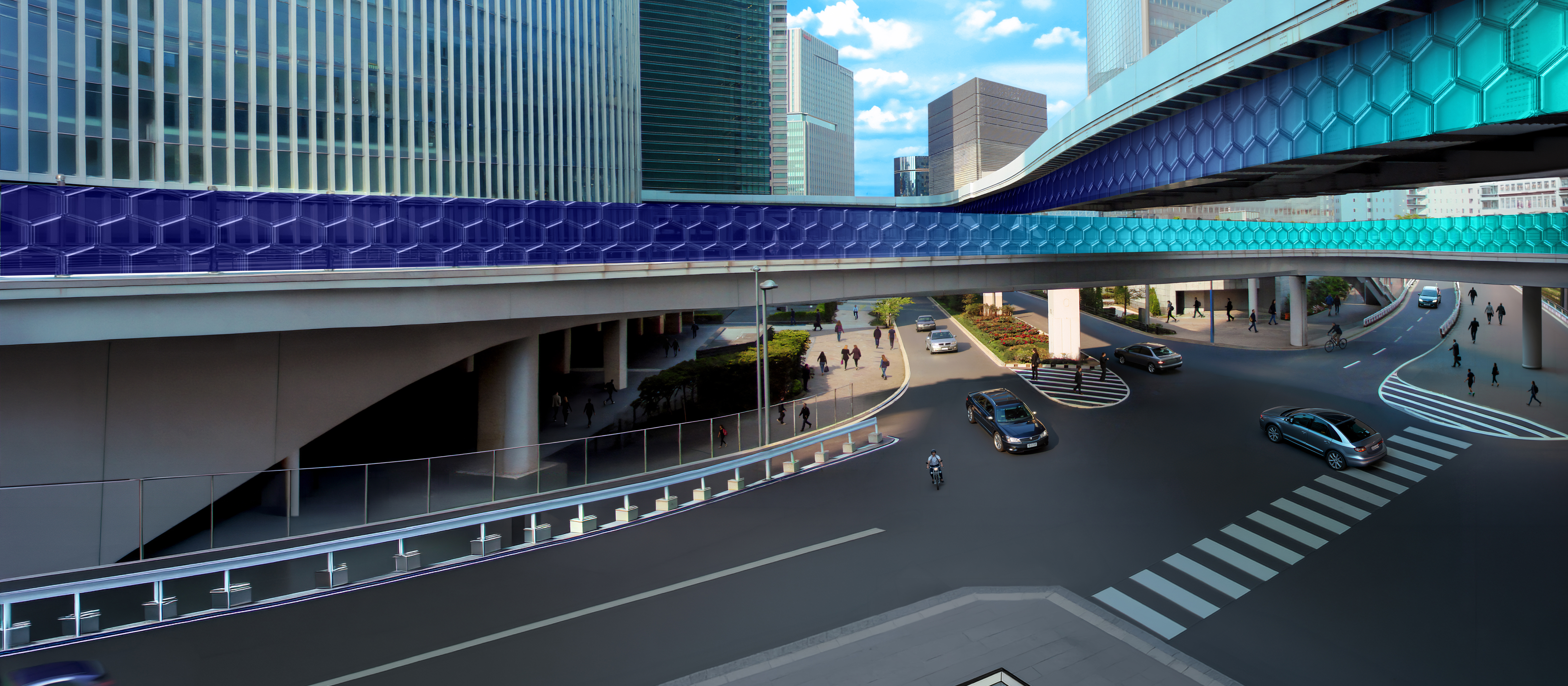 A street crossroad view from an overpass, with tall buildings all around it