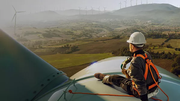 Worker resting and enjoying view on top of a windmill