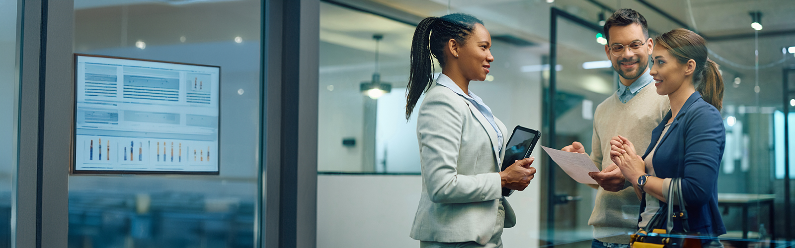 An employee conversing with two happy clients