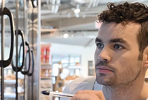A lretail employee taking stock of items in the freezer aisle