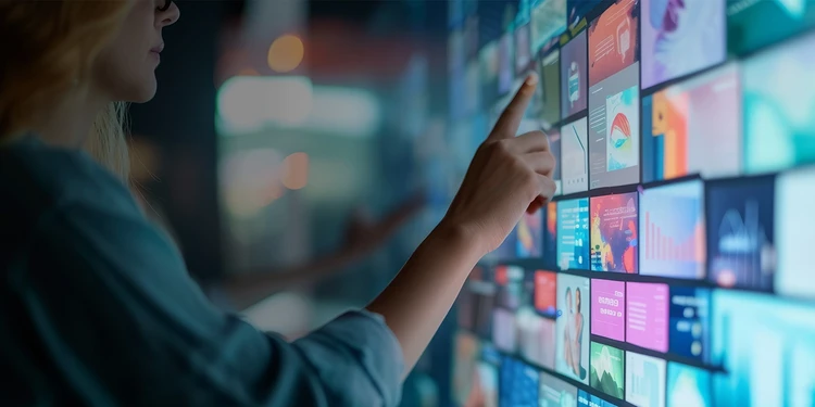 A young lady posing at her back staring outside through the colorful glass window of a building