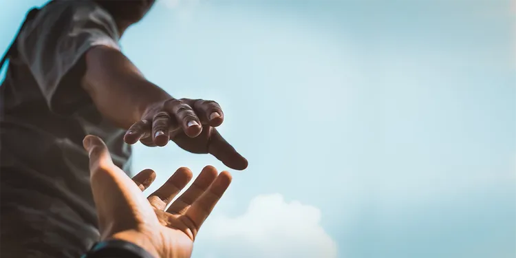a person giving hand to another
