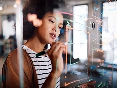 A woman drawing on a transparent board