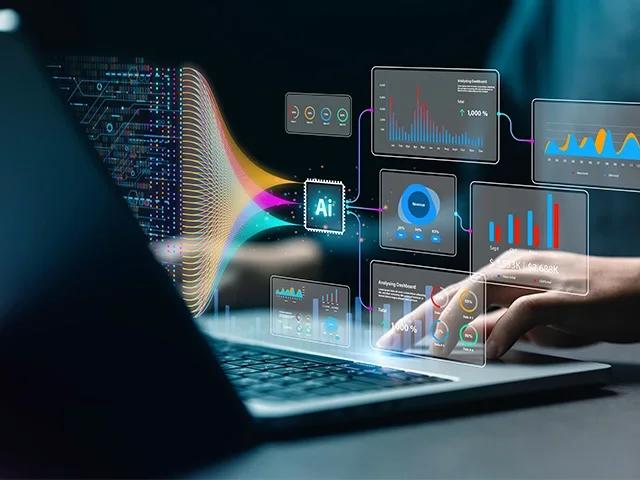 A person typing on a laptop, with the screen displaying various data and information.