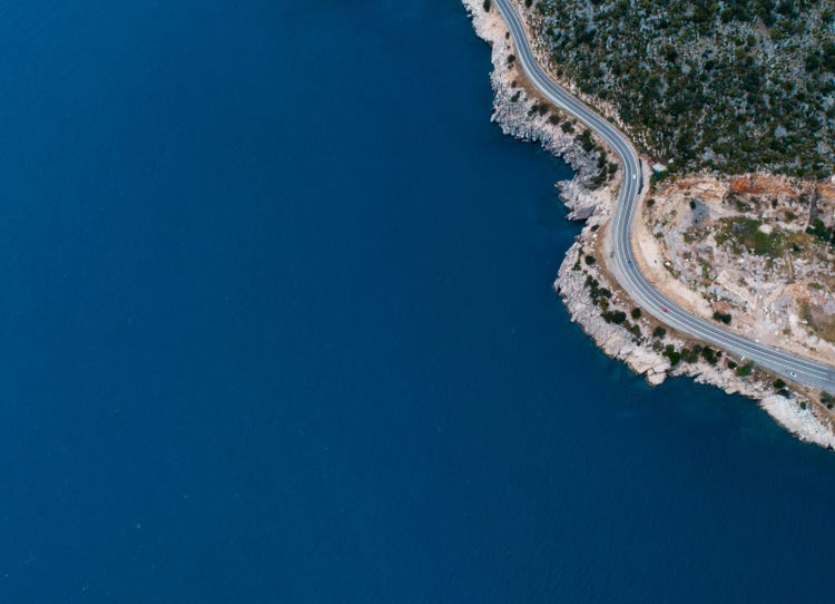 Aerial view of a body of water and a coastline highway.