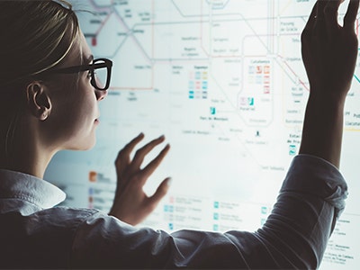 A woman looking at a backlit map