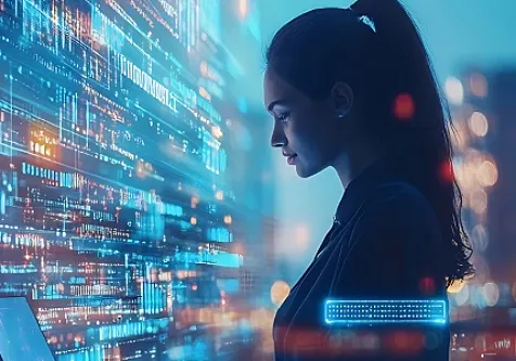 A girl wearing her hair in a high ponytail, working on a laptop