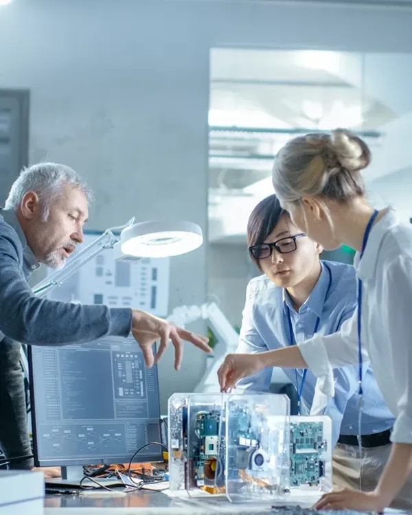 Three colleagues working on a computer chipboard