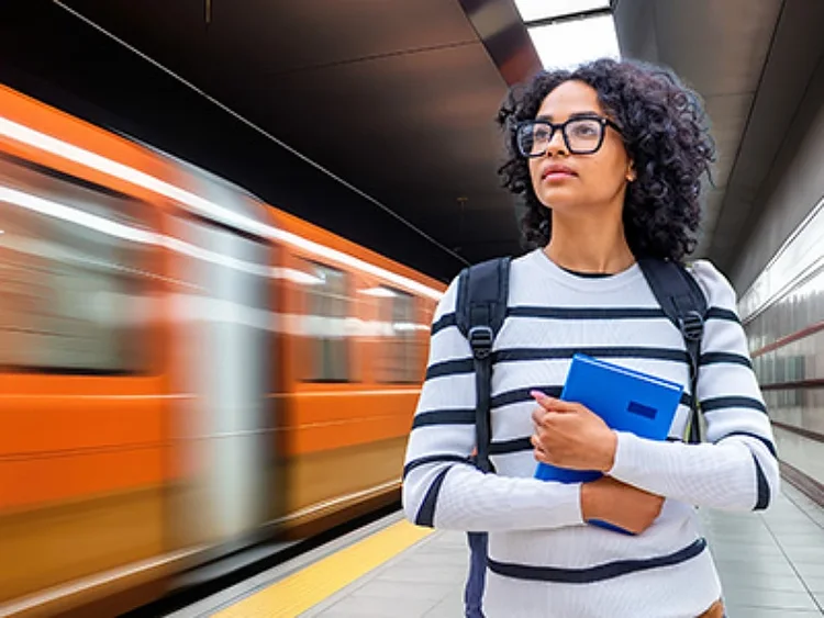Woman stands infront subway train
