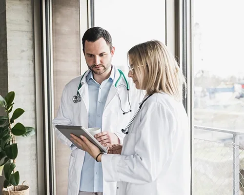 Two doctors discussing about a report with an electronic tablet in hand