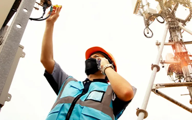 A worker talking through phone and testing the tower