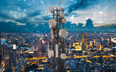 Telecommunication tower with 5G cellular network antenna on night city background