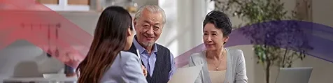 Three colleagues sitting on a table and discussing in an office