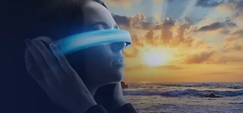 A woman wearing a VR headset standing by the ocean