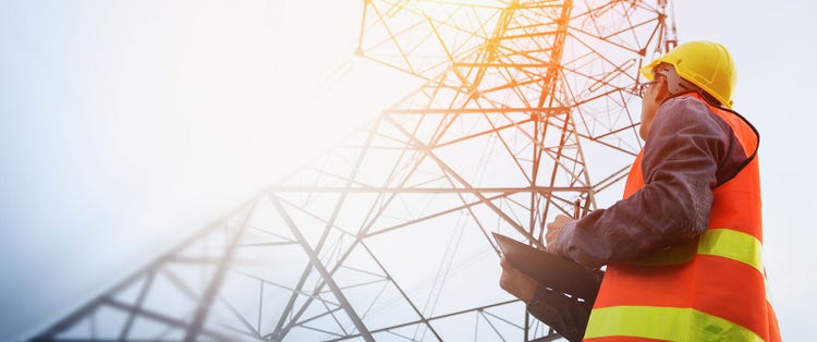 Electrical engineer standing near electric power station