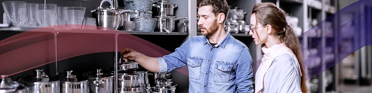 A man and woman examine a kitchen cabinet, discussing its features and design options.