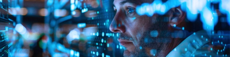 Close-up of a person’s face in profile, illuminated by blue digital light and reflections of data-like patterns.