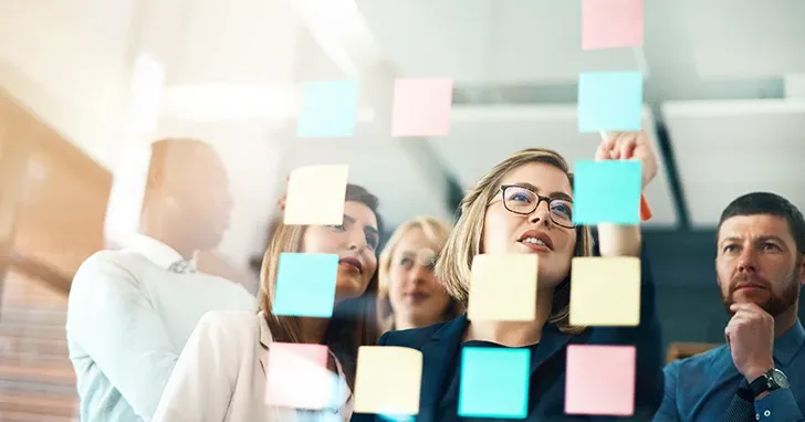 A group of people gathered around sticky notes