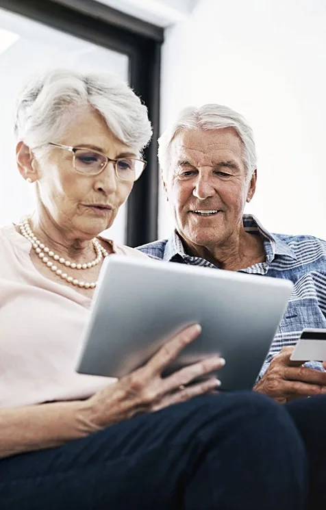 An elderly couple looking at a tablet