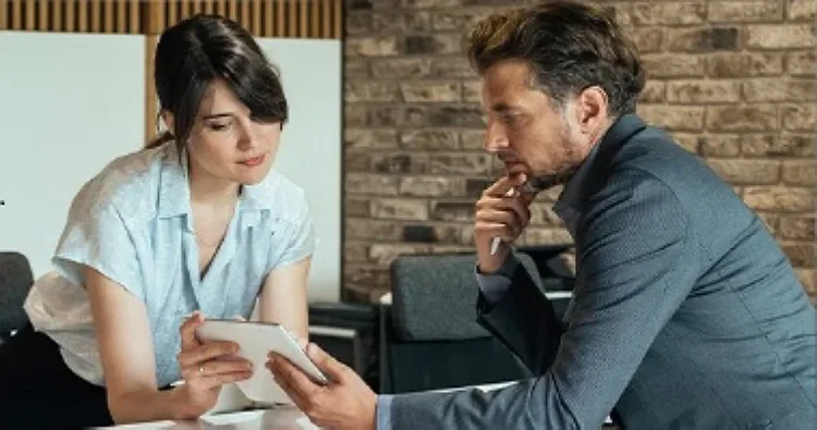 A lady is holding a tablet and explaining something to a man