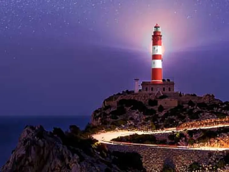 A winding road leading up to a lighthouse atop a cliff