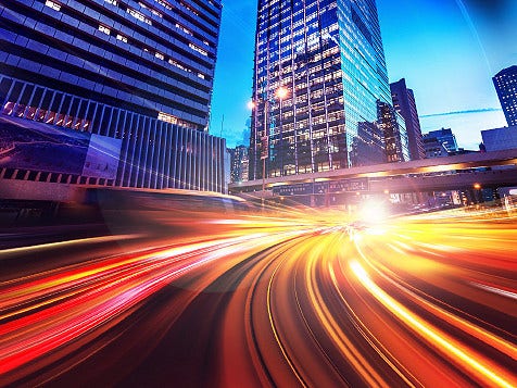 Cityscape with a busy highway at night