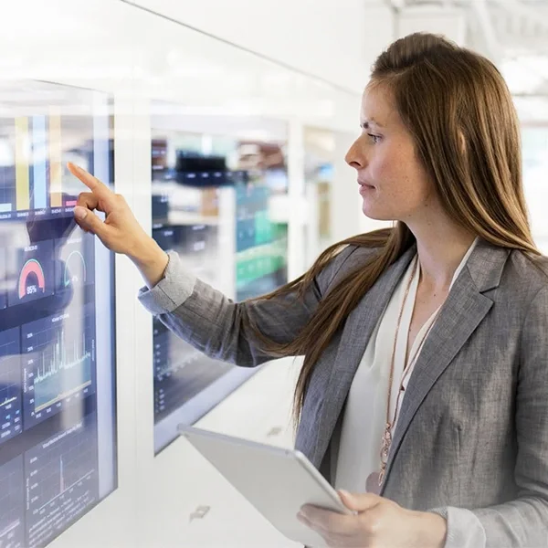 A lady touch a big screen displaying statistics chart