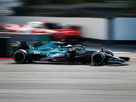 Aston Martin F1 car speeding on race track.