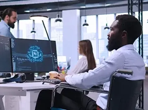 Developer in wheelchair works on AI model screen.