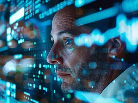 Man studies glowing digital data screens intently.