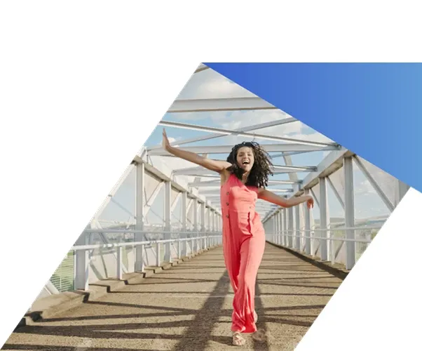 A person walks forward with arms outstretched on a modern pedestrian bridge, symbolizing digital transformation and business innovation.
